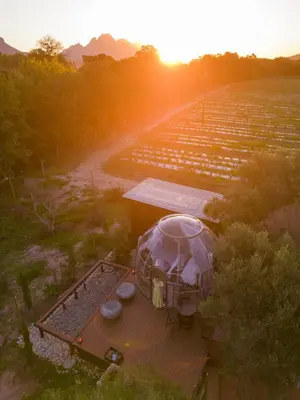 an aerial view of a farm with the sun setting at The Vino Dome By Once Upon a Dome Franschhoek in Franschhoek