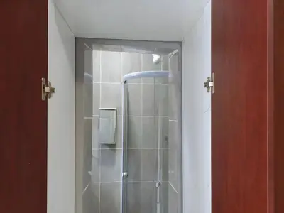 a shower with a glass door in a bathroom at Goshen Lodge Spencer in Cape Town