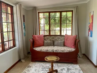 a living room with a couch in front of a window at Lakeview Cottage: Rural Retreat in Pampoenkraal