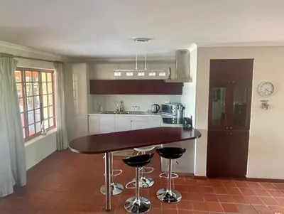 a kitchen with a table and two bar stools at Lakeview Cottage: Rural Retreat in Pampoenkraal