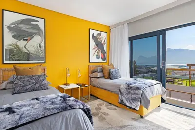 a bedroom with two beds and a yellow wall at The Baydreamer, where the view soothes your soul in Pringle Bay