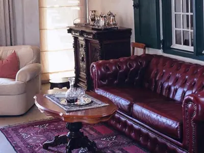 a living room with a leather couch and a table at Champagne De Kleijne Bos Pty Ltd in Paarl