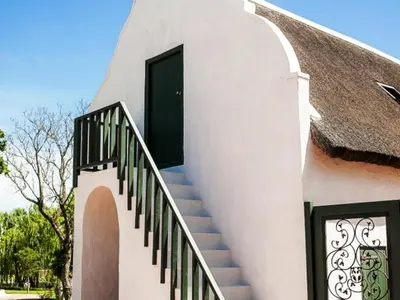 a staircase leading up to a house with a black door at Champagne De Kleijne Bos Pty Ltd in Paarl