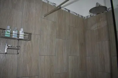 a bathroom with a shower with a wooden floor at 105 on Sarel Cilliers in Strand