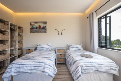 two beds in a room with a window at Pringle Bay getaway - 2 bedroom garden apartment in Pringle Bay