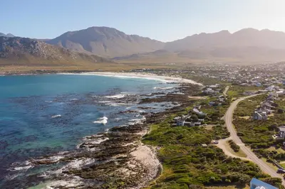 an aerial view of a beach with mountains in the background at Secure, luxurious with lovely views in Pringle Bay