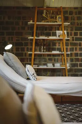 a room with a bed with pillows and a shelf at Secure, luxurious with lovely views in Pringle Bay