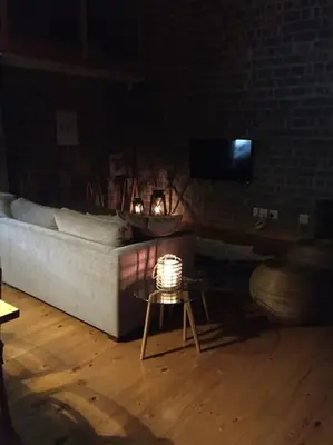 a living room with a bed and a table with a lamp at Secure, luxurious with lovely views in Pringle Bay