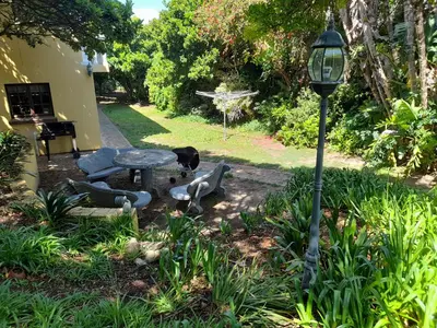a table and a street light in a garden at Lovely Concordia, rental unit with free parking in Cape Town