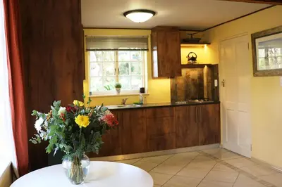 a vase of flowers sitting on a table in a kitchen at Lovely Concordia, rental unit with free parking in Cape Town