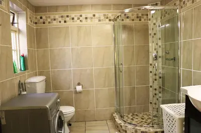 a bathroom with a shower and a toilet at Lovely Concordia, rental unit with free parking in Cape Town