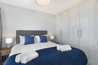 a bedroom with a large bed with towels on it at Ocean View 503 in Bloubergstrand