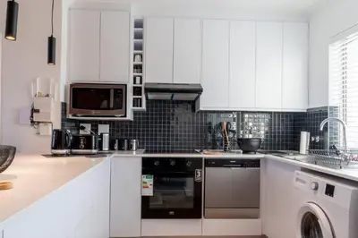 a kitchen with white cabinets and a dishwasher at Whale Rock 25 in Hermanus