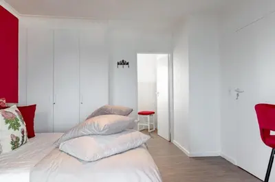 a bedroom with white walls and a bed with pillows at Whale Rock 25 in Hermanus
