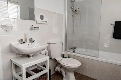 a bathroom with a toilet and a sink and a shower at Whale Rock 25 in Hermanus