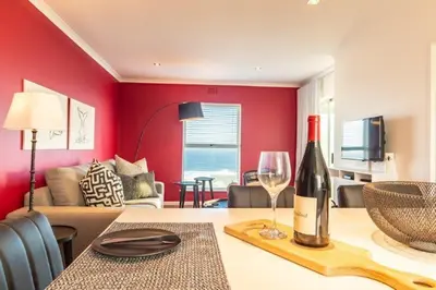 a bottle of wine on a table in a living room at Whale Rock 25 in Hermanus