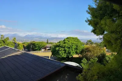 a roof of a house with trees and mountains in the background at The View Upstairs - A spacious apartment with a view in Durbanville