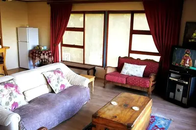 a living room with a couch and a tv at The View Upstairs - A spacious apartment with a view in Durbanville