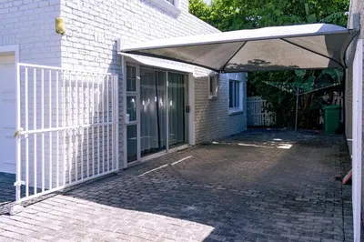 a patio with an umbrella in front of a house at The Mountainview Family Retreat in Hermanus