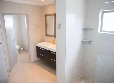 a white bathroom with a sink and a shower at 13 La Gratitude Luxury Apartment-with backup power for loadshedding in Stellenbosch