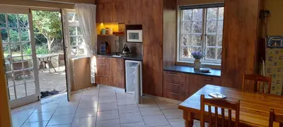 a kitchen with wooden walls and a table and windows at Lovely Kaapgracht, rental unit with free parking in Cape Town