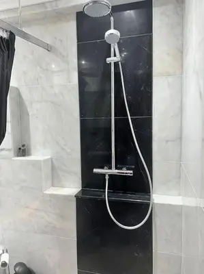 a shower in a bathroom with a black and white at Amazing! 7 bedroom villa with rooftop pool & views in Cape Town