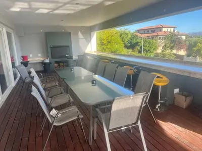 a room with a table and chairs on a balcony at Amazing! 7 bedroom villa with rooftop pool & views in Cape Town