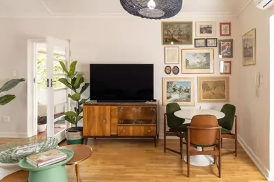 a living room with a tv and a table and chairs at Boho Chic Apartment Stellenbosch in Stellenbosch