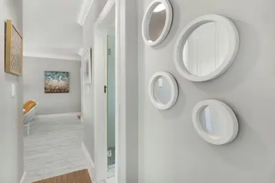 a hallway with three mirrors on a wall at Witsand 804 in Bloubergstrand