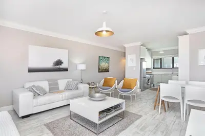 a living room with a white couch and a table at Witsand 804 in Bloubergstrand