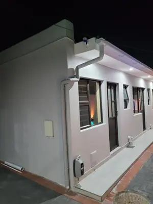 a white building with a pay phone on the side of it at MIRAJO Guest House in Cape Town
