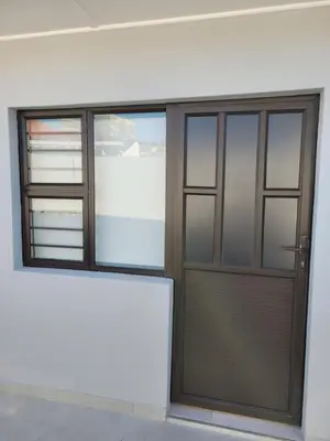 a building with a wooden door and windows at MIRAJO Guest House in Cape Town