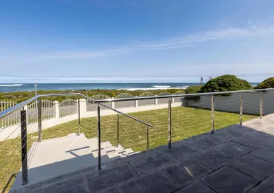 a balcony with a view of the ocean at Seafront Retreat in Sandbaai in Hermanus