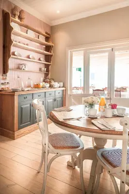 a kitchen with a wooden table and chairs in a room at Avenues Guest House in Stellenbosch