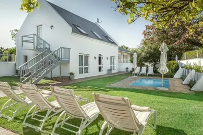a group of lawn chairs in front of a house at Avenues Guest House in Stellenbosch