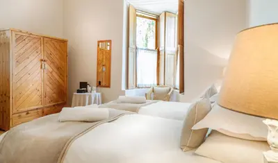 a white bedroom with two beds and a window at Avenues Guest House in Stellenbosch