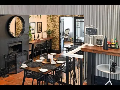 a dining room with a table and chairs and a fireplace at Ashbourne Boutique Guest House in Franschhoek