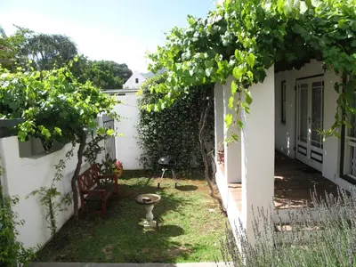 a garden with a table and a chair and a tree at Sunny Lane in Franschhoek