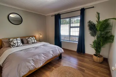 a bedroom with a bed and a large window at Magnificent Apartment in Cape Town