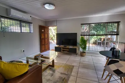 a living room with a couch and a tv at Magnificent Apartment in Cape Town