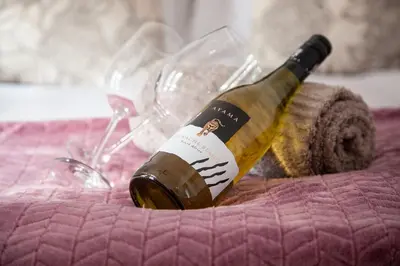 a bottle of wine sitting on a table with wine glasses at Ayama Wine Farm - Manor House in Wellington