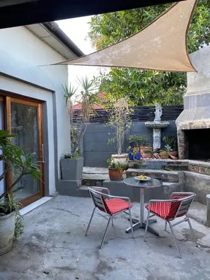 a patio with a table and two chairs and a fountain at Mabel View in Cape Town
