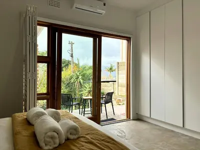 a bedroom with a bed with a stuffed animal on it at The Paarl Grand in Paarl
