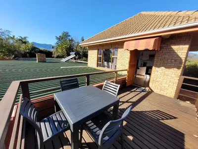 a patio with a table and chairs on a deck at Elegantie Apartment Protea 5 Lovell Avenue in Stellenbosch