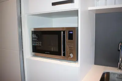 a microwave in aessedessed niche in a kitchen at 101 Bridgewater Apartment in Cape Town
