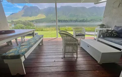 a porch with a couch and chairs and a table at Tranquility in Hermanus