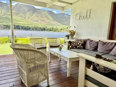 a living room with a couch and chairs and a table at Tranquility in Hermanus