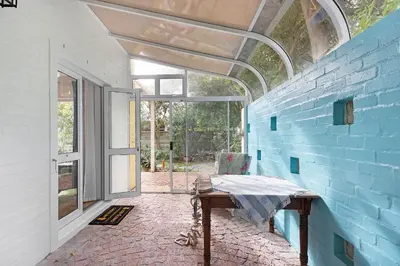 a room with a table and a blue wall at Sunset Yellow Cottage in Cape Town