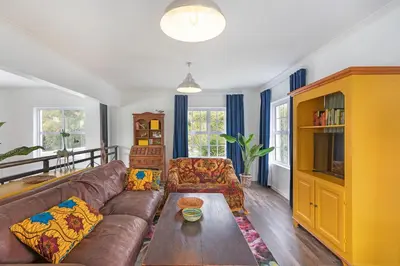a living room with a couch and a table at Sunset Yellow Cottage in Cape Town