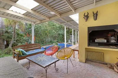 a patio with a table and chairs and a fireplace at Sunset Yellow Cottage in Cape Town
